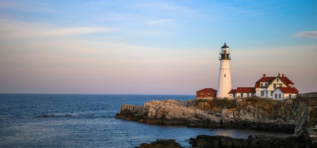 white lighthouse near body of water by Mercedes Mehling courtesy of Unsplash.